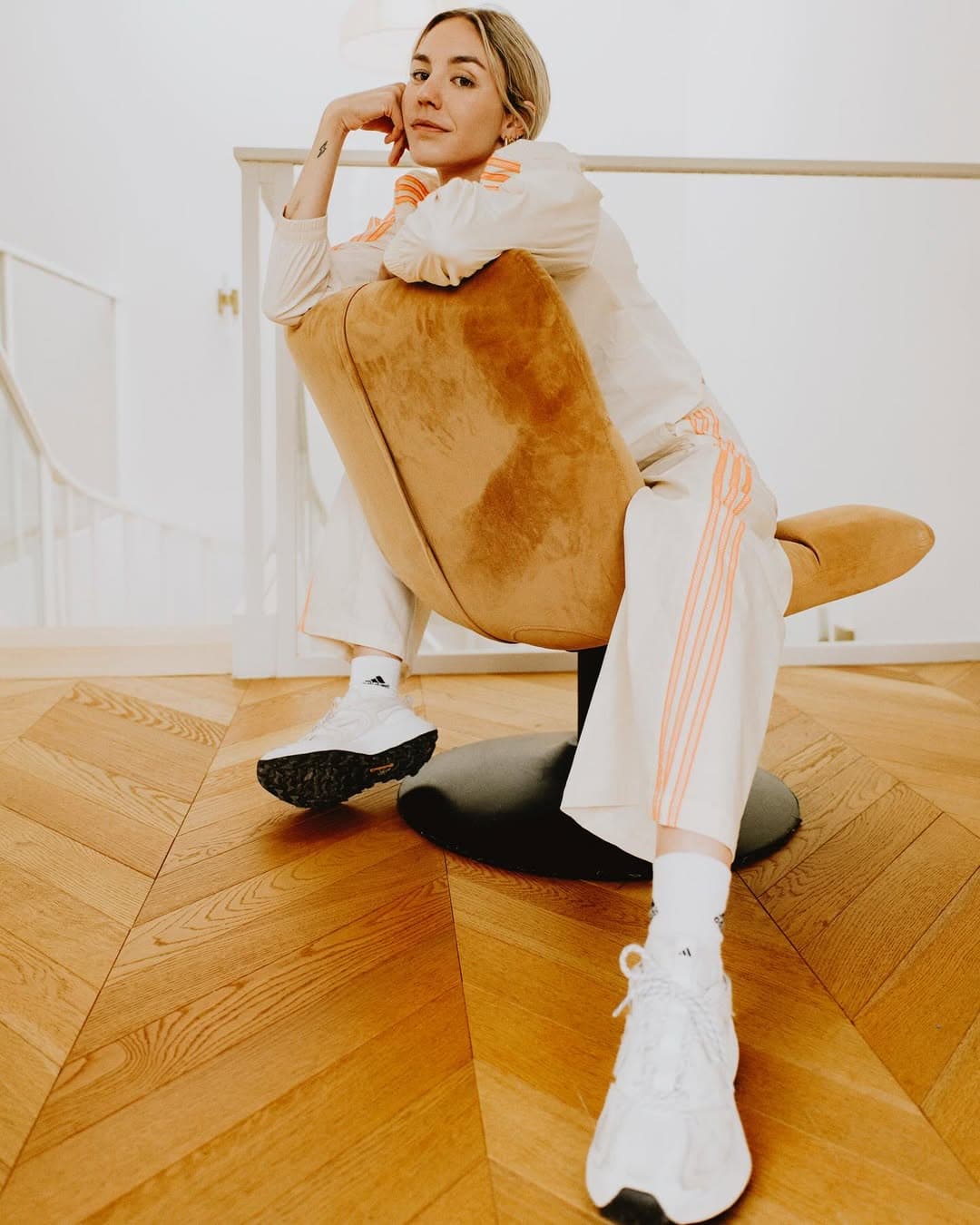 Cassandre Beaugrand off-duty in a chair, soft daylight.
