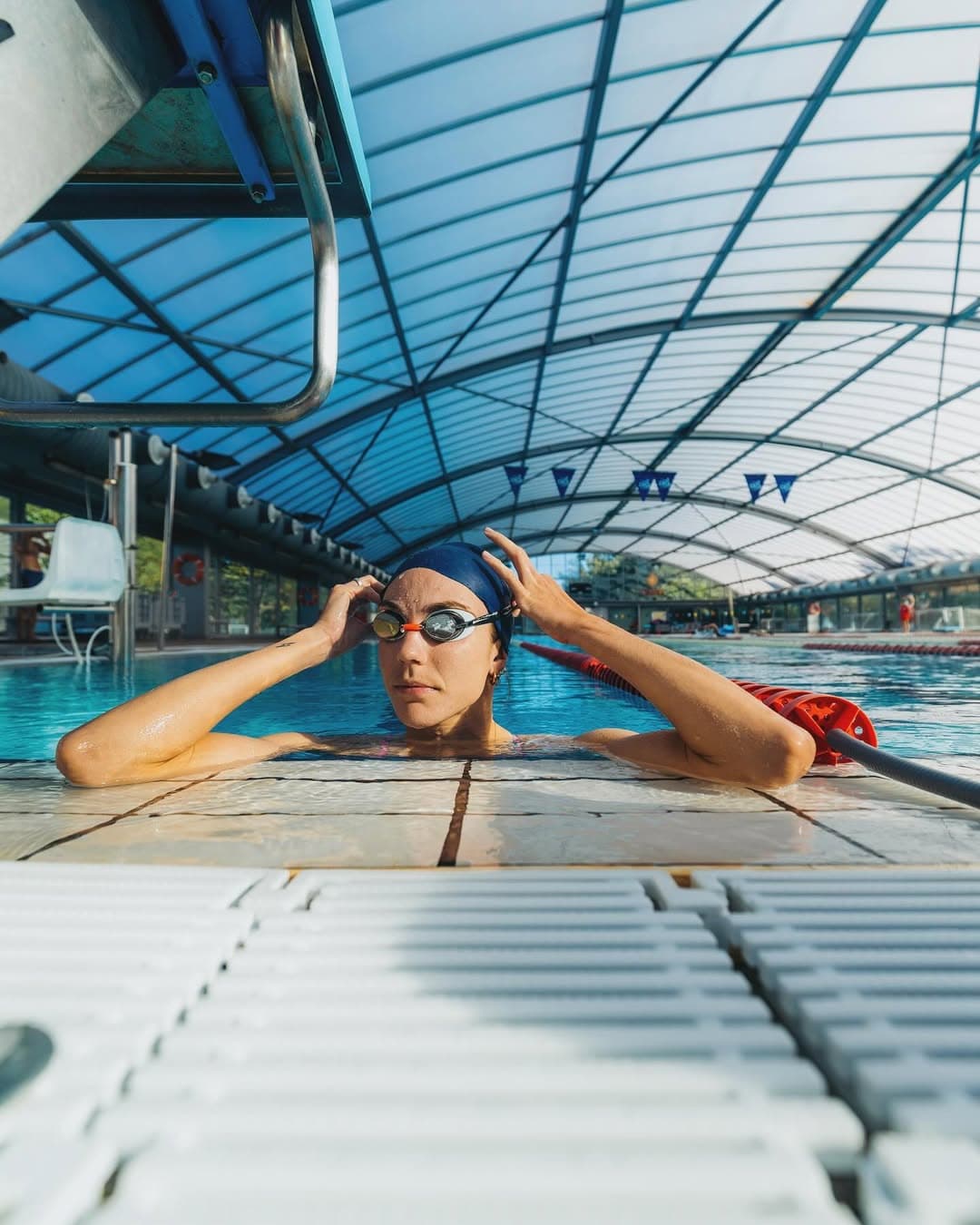Training in the pool, goggles in hand at the wall.